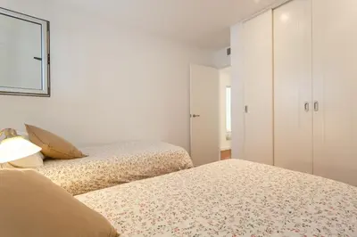 two beds in a bedroom with white cabinets at Calderón De La Barca in Cádiz