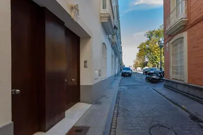 an empty street with a brown door on the side of a building at Calderón De La Barca in Cádiz