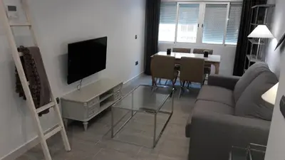 a living room with a couch and a tv and a table at GUESTING VELAZQUEZ in Cádiz
