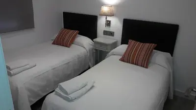 a room with two beds with towels on them at GUESTING VELAZQUEZ in Cádiz