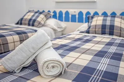 a rolled up towel sitting on top of two beds at Multi Apartamentos La Kasbah in Jerez de la Frontera