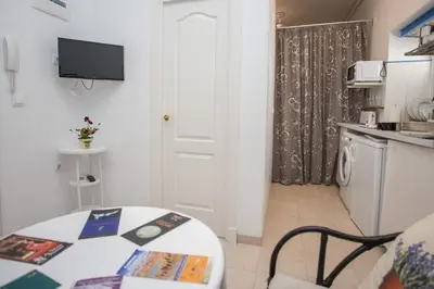 a small room with a table and a kitchen at Multi Apartamentos La Kasbah in Jerez de la Frontera