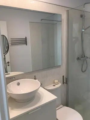 a bathroom with a sink and a toilet and a mirror at Diseño y confort junto a la catedral in Cádiz