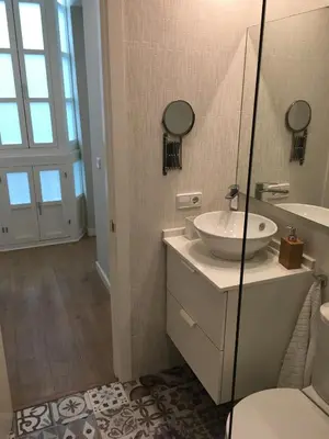 a bathroom with a sink and a toilet and a mirror at Diseño y confort junto a la catedral in Cádiz