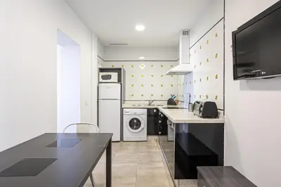 a kitchen with a washing machine and a washer and dryer at Apartamentos Turísticos La Boutique del Mar in Conil de la Frontera