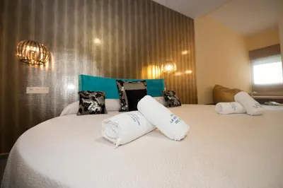 a bedroom with two beds with white pillows at Apartamentos Turísticos La Boutique del Mar in Conil de la Frontera