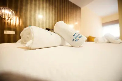 two rolled towels on a bed in a hotel room at Apartamentos Turísticos La Boutique del Mar in Conil de la Frontera