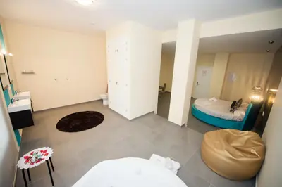 a large room with a bed and a mirror at Apartamentos Turísticos La Boutique del Mar in Conil de la Frontera