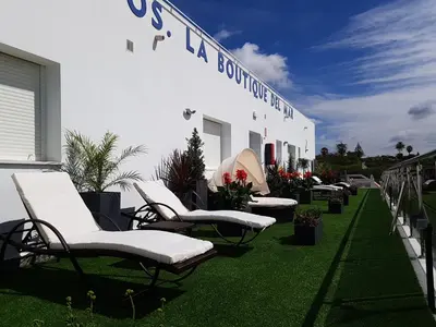 a group of lawn chairs sitting outside of a building at Apartamentos Turísticos La Boutique del Mar in Conil de la Frontera