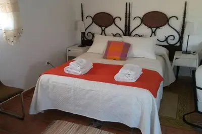 a bedroom with a bed with two towels on it at Bungalow Cuesta de la Rosa. Casita rural con encanto y vistas in Arcos de la Frontera