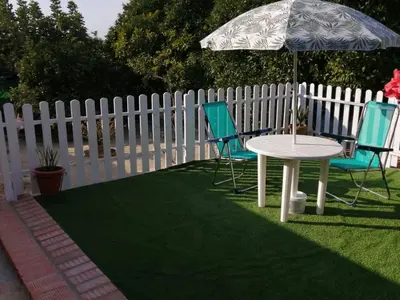 a white fence with two chairs and a table and an umbrella at Bungalow Cuesta de la Rosa. Casita rural con encanto y vistas in Arcos de la Frontera