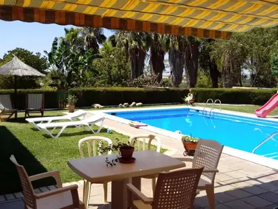 a patio with a table and chairs next to a swimming pool at Bungalow Cuesta de la Rosa. Casita rural con encanto y vistas in Arcos de la Frontera