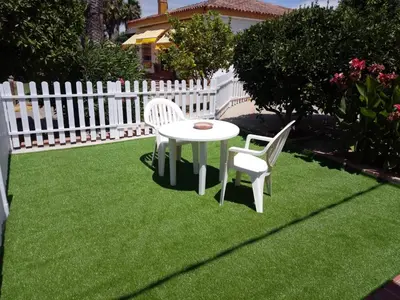 a table and two chairs on a lawn with a fence at Bungalow Cuesta de la Rosa. Casita rural con encanto y vistas in Arcos de la Frontera