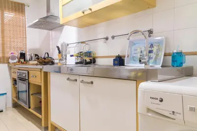 a kitchen with white cabinets and a sink at Apartamento Patri in Jerez de la Frontera