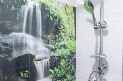 a shower curtain with a waterfall mural in a bathroom at Apartamento Patri in Jerez de la Frontera