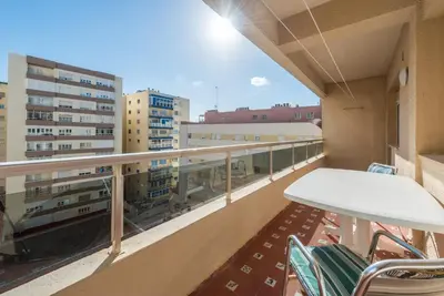 a balcony with a table and chairs and buildings at Villamar in Cádiz