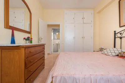 a bedroom with a bed and a dresser and a mirror at Villamar in Cádiz