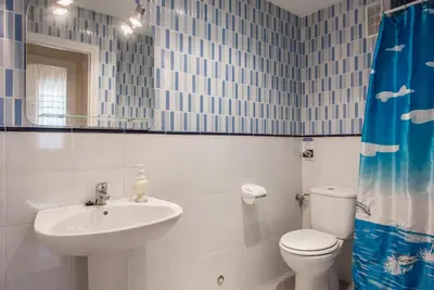 a bathroom with a sink and a toilet and a mirror at Villamar in Cádiz