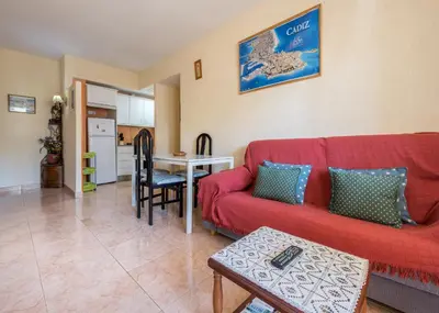a living room with a red couch and a table at Villamar in Cádiz