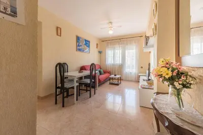 a living room with a red couch and a table at Villamar in Cádiz