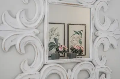 a mirror on a wall with three pictures of flowers at Apartamento Sueño de la Caleta in Cádiz