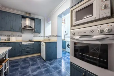a kitchen with blue cabinets and blue tile floors at Gran Apartamento Avenida 57 in Cádiz