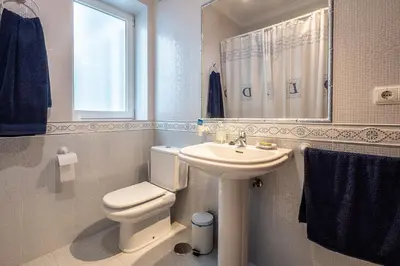 a bathroom with a white toilet and a sink at Gran Apartamento Avenida 57 in Cádiz