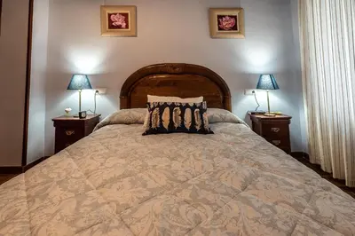 a bedroom with a large bed with two lamps at Gran Apartamento Avenida 57 in Cádiz
