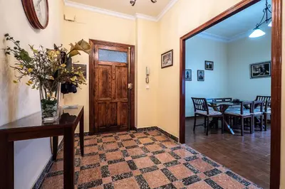 a hallway with a door and a table with chairs at Gran Apartamento Avenida 57 in Cádiz
