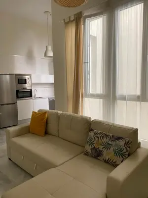 a living room with a couch in front of a window at Apartamento nuevo en casa tipo palacio in Cádiz