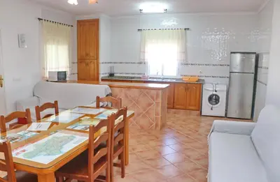 a kitchen and dining room with a table and chairs at Chalet Aroca in Conil de la Frontera