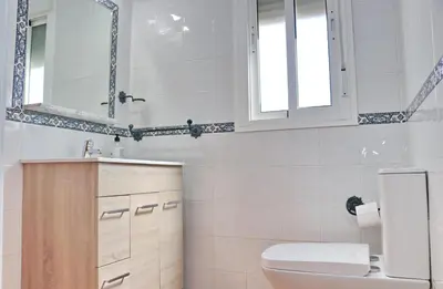 a bathroom with a toilet and a sink and a mirror at Chalet Aroca in Conil de la Frontera