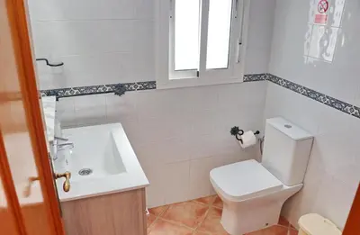 a bathroom with a white toilet and a sink at Chalet Aroca in Conil de la Frontera