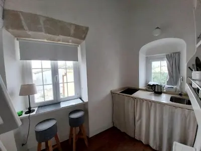 a kitchen with a sink and a counter with two stools at Estudio Boutique Arenal - Cama buhardilla in Jerez de la Frontera