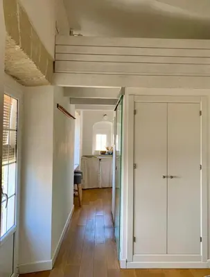a hallway with white walls and a door and a room at Estudio Boutique Arenal - Cama buhardilla in Jerez de la Frontera