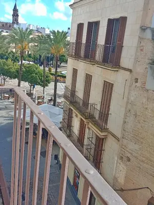 a balcony of a building with palm trees next to it at Estudio Boutique Arenal - Cama buhardilla in Jerez de la Frontera