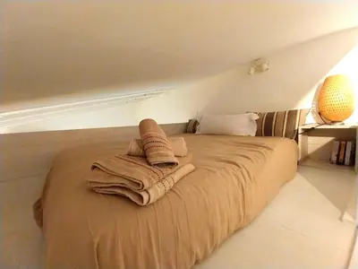 a bed with blankets on it in a room at Estudio Boutique Arenal - Cama buhardilla in Jerez de la Frontera