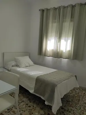 a bedroom with a bed and a window at Hostal Mellizo in Lebrija