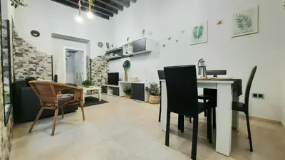 a kitchen and living room with a table and chairs at Apartamento Levante in Cádiz
