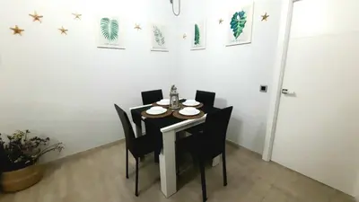 a dining room table with black chairs and stars on the wall at Apartamento Levante in Cádiz