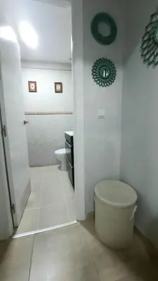a white bathroom with a toilet and a sink at Apartamento Levante in Cádiz