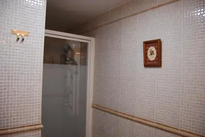 a bathroom with a shower and a clock on the wall at Apartamento Levante in Cádiz