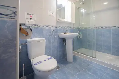 a bathroom with a toilet and a sink and a shower at Apartamento Malibu Cadiz playa in Cádiz