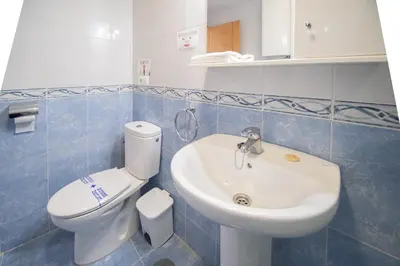 a bathroom with a white toilet and a sink at Apartamento Malibu Cadiz playa in Cádiz