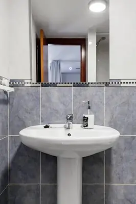a bathroom with a white sink and a mirror at SH El Teatro. Dúplex industrial en el Falla. in Cádiz