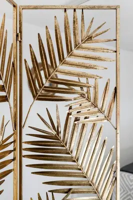 a gold mirror with a palm tree leaf design at SH El Teatro. Dúplex industrial en el Falla. in Cádiz