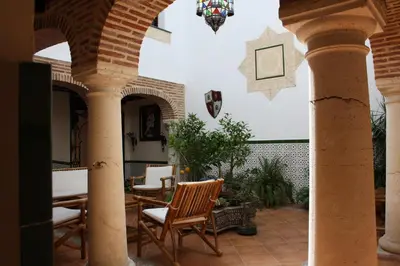 a patio with chairs and tables in a building at Casa Rural Sidonia in Medina Sidonia