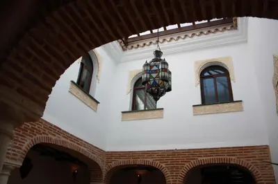 a building with two windows and a statue at Casa Rural Sidonia in Medina Sidonia