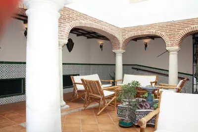 a patio with a table and chairs and columns at Casa Rural Sidonia in Medina Sidonia