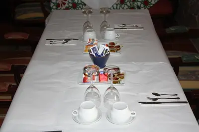 a table with a white table cloth with cups and glasses at Casa Rural Sidonia in Medina Sidonia